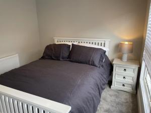 a bedroom with a bed and a night stand at The Greig 1A in Wadhurst