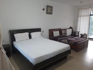 a bedroom with a large bed and a bed sidx sidx sidx at New Sunrise Hotel in Batticaloa