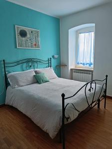 a bedroom with a bed with blue walls and a window at Guardando le Mainarde 