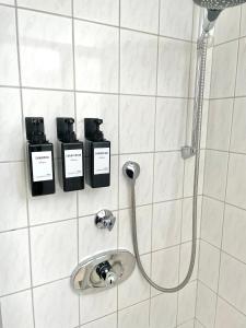 a bathroom with a shower with three bottles of shampoo at Entspannte Souterrain Wohnung in Munster im Heidekreis
