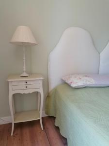 a bedroom with a bed and a nightstand with a lamp at LAVANDA appartamento in Vigliano Biellese