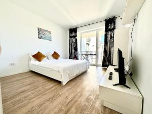 a bedroom with a bed and a flat screen tv at Kasper Coresi Mall - Rise Private Apartments & Suites in Braşov