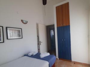 a bedroom with a bed and a blue door at Villa Aroma in Polychrono