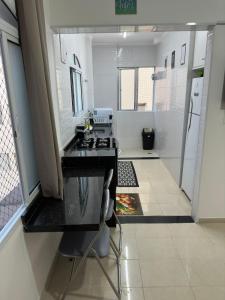 a kitchen with a counter and a sink in a room at Apartamento frente ao mar com varanda e piscina in Praia Grande