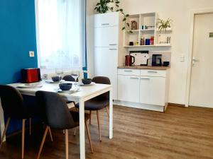 cocina con mesa blanca y sillas en Schöne Altbauwohnung auf dem Land, en Kallham