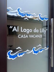 ガルニャーノにあるAl Lago da Lillyのラガ・デル・フィリング・カソーナを読み取る看板付きのガラスドア