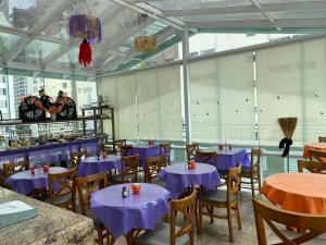 a dining room with purple tables and chairs at Upper Hotel in São Paulo