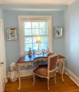 a table with a lamp and a chair in a room at 9 Booth Lane in Haverford