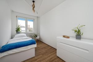 ein weißes Schlafzimmer mit einem Bett und einem Fenster in der Unterkunft Apartament Octopus Sopot Kamienny Potok in Sopot