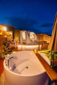 a bath tub sitting on top of a patio at night at เดอะเนเจอร์ ม่อนแจ่ม The nature camping monjam in Mon Jam