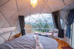uma pessoa com os pés em cima de uma cama numa tenda cúpula em เดอะเนเจอร์ ม่อนแจ่ม The nature camping monjam em Mon Jam