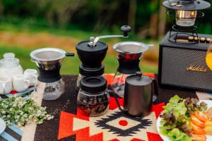 una mesa con 2 moledoras de café y un microondas en เดอะเนเจอร์ ม่อนแจ่ม The nature camping monjam en Mon Jam