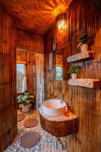 a bathroom with a sink and a wooden wall at เดอะเนเจอร์ ม่อนแจ่ม The nature camping monjam in Mon Jam