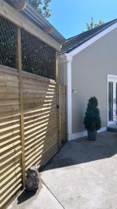 a wooden fence next to a house with a door at Sèid Bò - Sleeps 6 - NEW Private 6 Person HotTub Available in Burnfoot