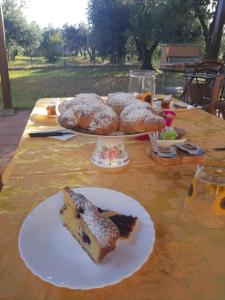 einen Tisch mit einem Stück Kuchen und Gebäck darauf in der Unterkunft Il Girasole B&B in Cretone