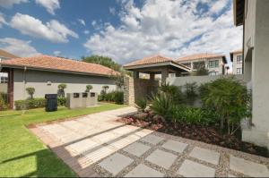 a house with a walkway in front of a yard at Fourways Luxe Suite in Sandton