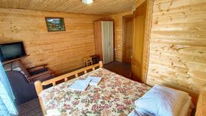 um quarto com uma cama num chalé de madeira em Казка Карпат em Dragobrat