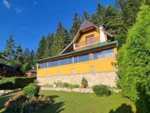 una gran casa amarilla con muchas ventanas en Green Forest en Vlasic