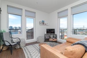 a living room with a couch and some windows at Be Close To Chinatown When You Are In The Ironwork Building in Victoria