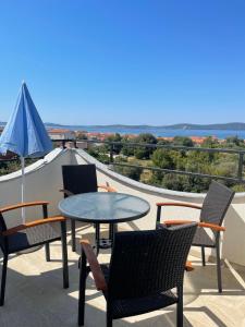 eine Terrasse mit Stühlen und einem Tisch auf dem Dach in der Unterkunft Apartments villa M&M in Bibinje