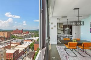 a kitchen and dining room with a view of a city at 'Endless Sunset Retreat' A Luxury Downtown Condo with Panoramic Mountain Views at Arras Vacation Rentals in Asheville