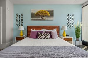 a bedroom with a large bed with purple pillows at 'Endless Sunset Retreat' A Luxury Downtown Condo with Panoramic Mountain Views at Arras Vacation Rentals in Asheville