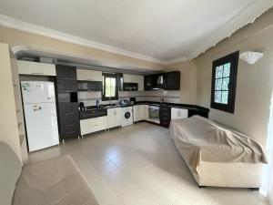 a large kitchen with a white refrigerator and appliances at Dove Apart Hotel in Fethiye