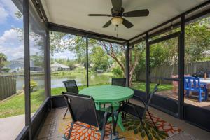 a screened in porch with a green table and chairs at Paradise Palm in Jacksonville Beach