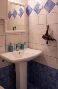 La salle de bains est pourvue d'un lavabo blanc et d'un miroir. dans l'établissement Olga & Dimitris, à Kalamata