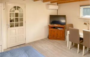 Habitación con mesa, TV y puerta. en Cozy Home In Tiendeveen With Wifi, en Tiendeveen