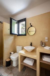 Monopati Eco Villas في Raches: حمام مع حوض ومرحاض ومرآة