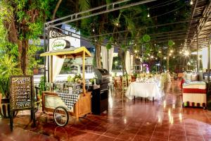 un restaurante con mesas y un carrito de comida. en Grand Inna Tunjungan, en Surabaya