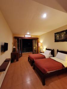 a hotel room with two beds and a balcony at Dalia Budget Hotel in Senggigi