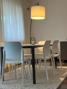 a dining room table with two chairs and a lamp at Casa Parisi Lago Maggiore in Baveno