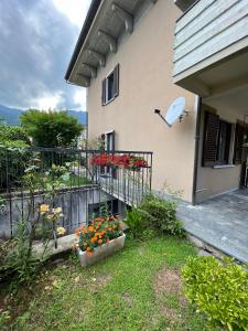 a house with a balcony with flowers in a yard at Casa Parisi Lago Maggiore in Baveno