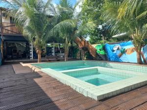 a swimming pool with palm trees next to a building at Pousada Tupaiú in Alter do Chao