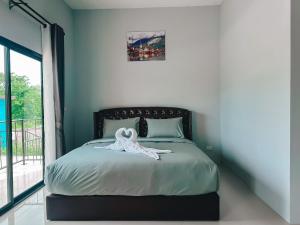Un dormitorio con una cama con una bata blanca. en Tuscany Hotel Buriram en Buriram