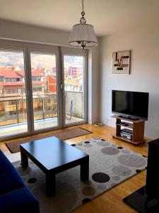 a living room with a tv and a coffee table at Blerta's apartment in Prizren