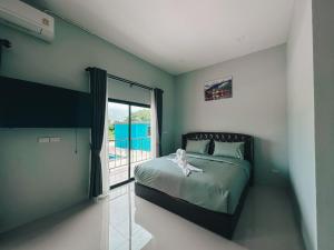 a bedroom with a bed and a large window at Tuscany Hotel Buriram in Buriram