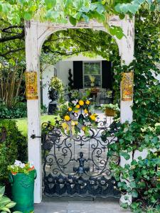 an open gate to a garden with yellow flowers at 9 Booth Lane in Haverford