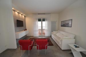 een woonkamer met een witte bank en rode stoelen bij Rada in Marina di Campo