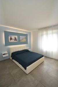 een slaapkamer met een groot bed in een witte kamer bij Rada in Marina di Campo