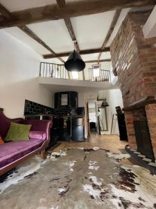 uma sala de estar com um sofá roxo e uma lareira de tijolos em Egos em Castle Donington