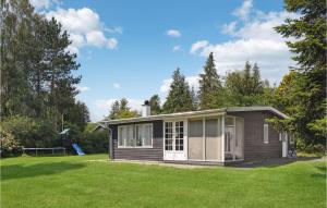 ein kleines Haus auf einem Feld mit Hof in der Unterkunft Gorgeous Home In Rnde With Kitchen in Rønde