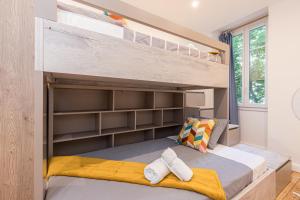 Ce lit superposé se trouve dans un dortoir doté d'étagères. dans l'établissement FEEL HOME - FOCH 28, à Nice