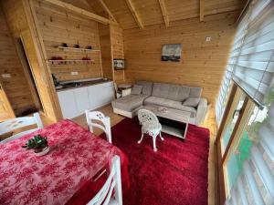 een woonkamer met een bank en een tafel en stoelen bij Boljesestre Lake retreat in Golubovci