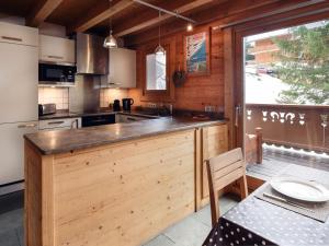 una cucina con bancone in legno e tavolo di Chalet Chaleureux à Méribel : Cheminée, Jacuzzi, Proche Commerces, 4 Chambres en Suite - FR-1-688-18 a Méribel