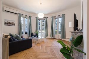 - un salon avec un canapé noir et quelques fenêtres dans l'établissement FEEL HOME - FOCH 28, à Nice