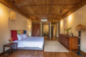 Hòa BìnhにあるHỒ ĐÁ CỔ THIÊN LONG Hoa Leの白いベッドと木製の天井が備わるベッドルーム1室が備わります。