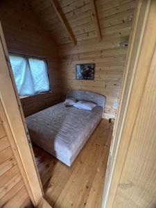een slaapkamer in een blokhut met een bed erin bij Boljesestre Lake retreat in Golubovci